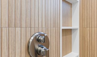 Bright wooden shower wall with built-in white shelves for bathroom storage and organization.