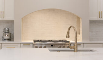 Bright modern kitchen with white cabinetry, marble countertops, and stylish lighting fixtures. Perfe.