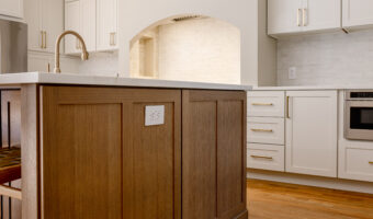 Modern kitchen with white cabinets and a wooden island, showcasing professional home renovation and.