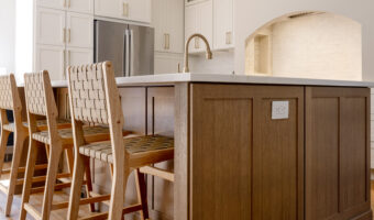 Modern kitchen with white cabinets, wooden island, and bar stools for home renovation projects.