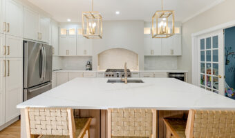 Modern white kitchen with island, stainless steel appliances, and ample cabinetry for home renovatio.
