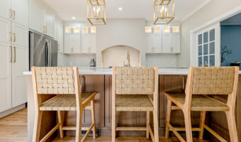 Bright modern kitchen with white cabinetry, wooden bar stools, and stylish pendant lighting, perfect.