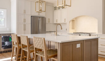 Modern kitchen with white cabinets, a large island, and stainless steel appliances, perfect for home.