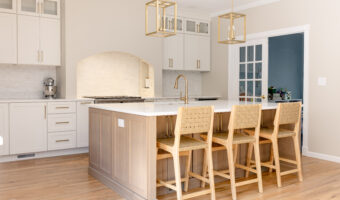 Modern kitchen with white cabinets, a central island, and wooden bar stools, perfect for home renova.