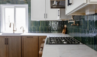 Modern kitchen with green tile backsplash and white cabinetry, showcasing stylish and functional kit.
