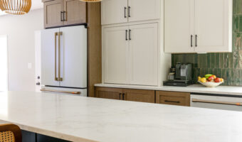 Bright modern kitchen with white cabinets, green tiled backsplash, and marble countertop, showcasing.