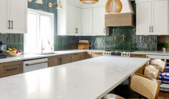Modern kitchen with white cabinets, green tile backsplash, and a large marble island, inspired by Th.