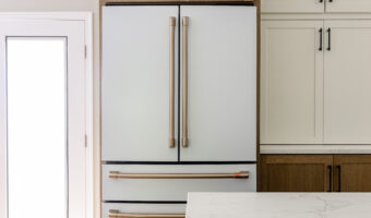 Modern white kitchen refrigerator with sleek handles in a contemporary kitchen setting.