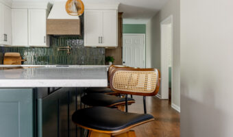 Modern kitchen with white cabinets, green backsplash, and wooden accents, showcasing contemporary ho.